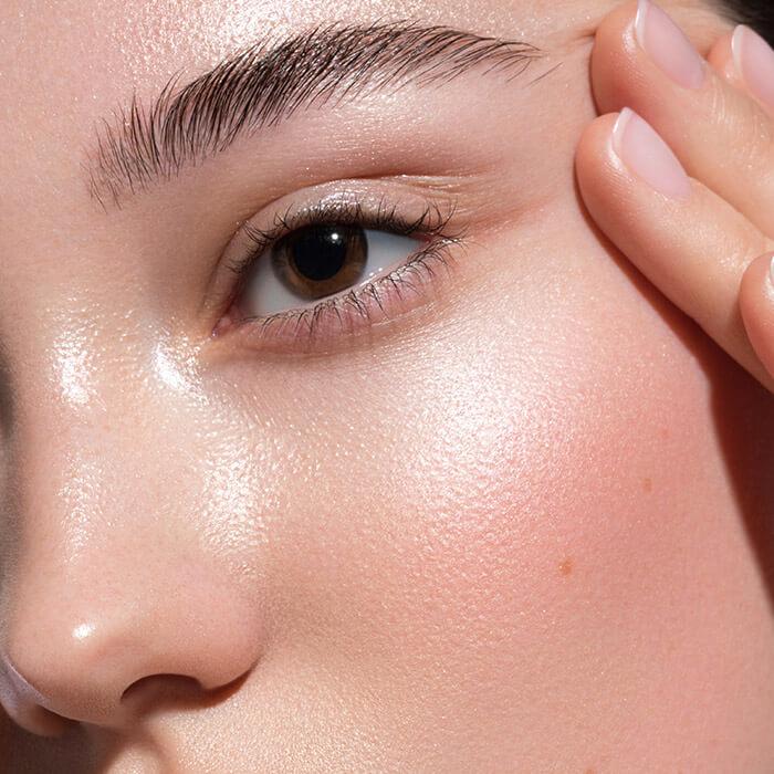A closeup photo of a model face with beautiful glowy skin